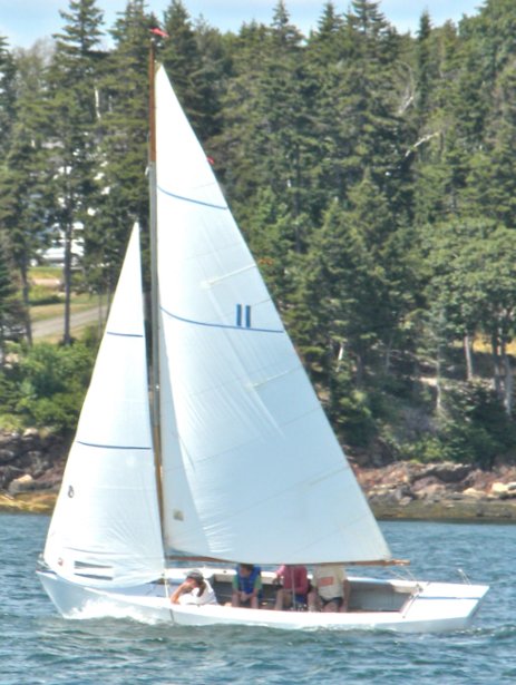 Small point one design sailboat under sail